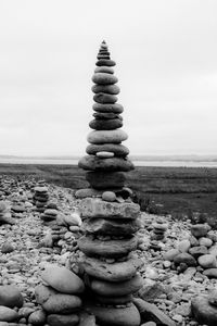 Stack of stones on beach against sky