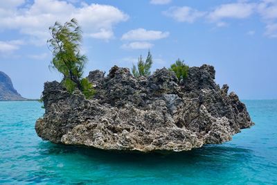 Rock formation in sea against sky