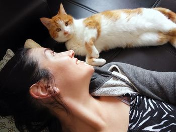 Full length of cat relaxing on bed at home