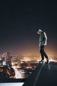 Man standing on illuminated city against sky at night