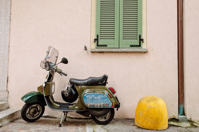 Motor scooter parked on street against building