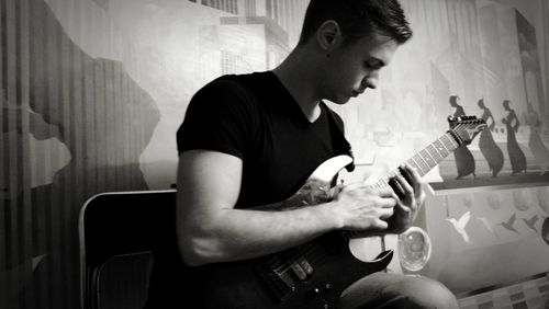 Young man playing guitar at home