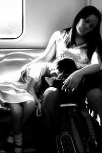 Side view of smiling young woman sitting in car