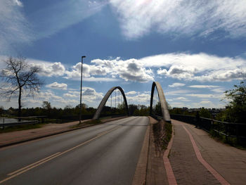 Road by bridge against sky