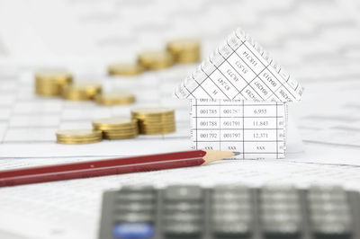 High angle view of documents and coins on table