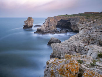 Long exposure above rocks and sea