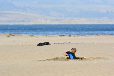 Full length of boy on beach against sky