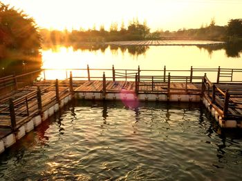 Pier on lake against sky during sunset