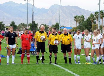 Group of people standing on soccer field