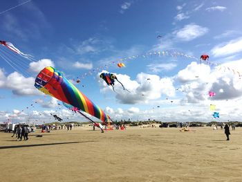 Kites flying at beach against sky