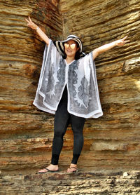 Full length portrait of happy young woman standing outdoors