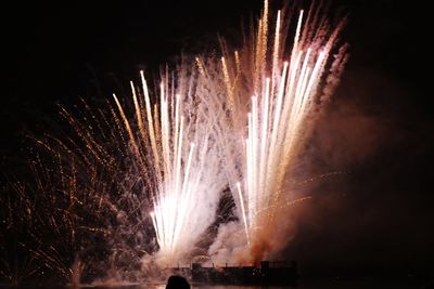 Low angle view of fireworks against sky at night