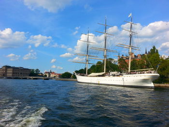 White sailing ship in sea against sky