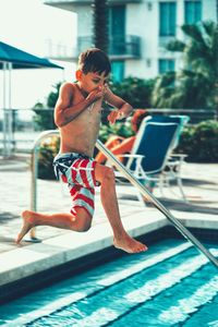 Boy jumping in swimming pool