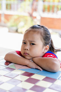 Angry little girl looking at camera. unhappy child feeling upset and sad with negative attitude. 