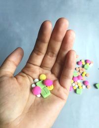 Cropped hand of person holding colorful medicines