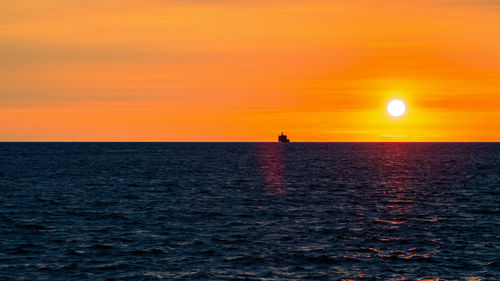 Scenic view of sea against orange sky