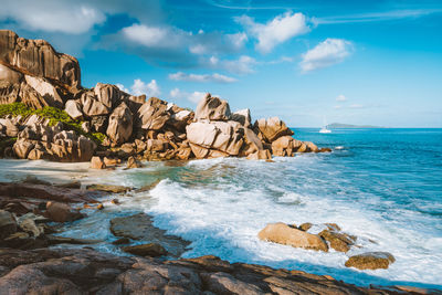 Scenic view of rocks on beach against sky