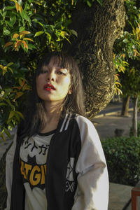 Portrait of a teenage girl standing against plants