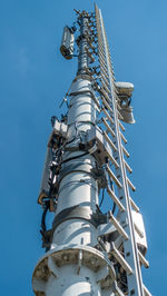 Low angle view of communications tower against blue sky