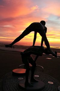 Silhouette man against sea during sunset