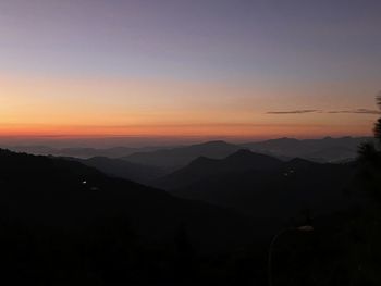 Scenic view of silhouette mountains against sky at sunset