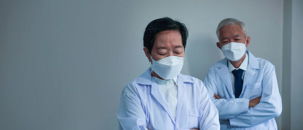People in front of two men with arms outstretched