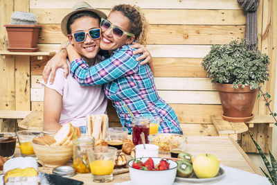 Mother and son embracing while sitting by food on table