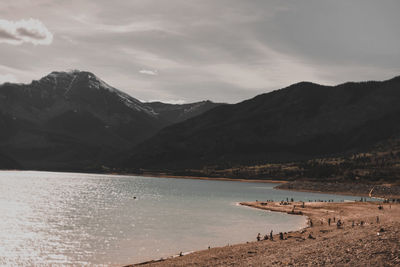 Scenic view of lake by mountains against sky