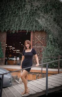 Full length of young woman sitting on staircase