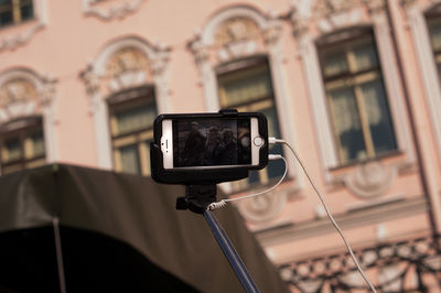 Friends taking selfie through monopod