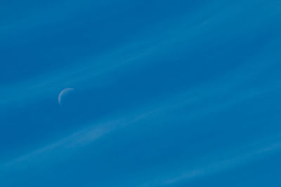 Low angle view of moon in blue sky