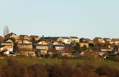 Houses on field against clear sky