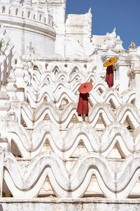 Monks with umbrellas standing on temple