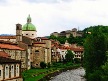 Canal amidst buildings in city against sky