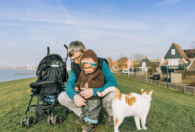 People with cat against sky