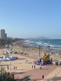 People on beach against clear sky