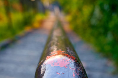 Close-up of rusty metallic railing against blurred background