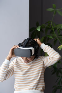 Inspired afro woman at home put on vr helmet to enjoy virtual reality online game cyber simulation