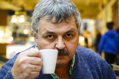 Portrait of man drinking coffee cup