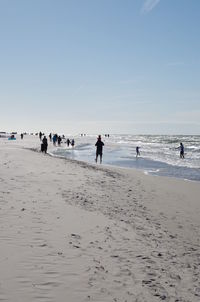 People on beach against clear sky