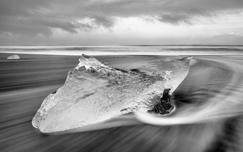 Close-up of wave on beach against sky