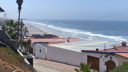 High angle view of buildings by sea against sky