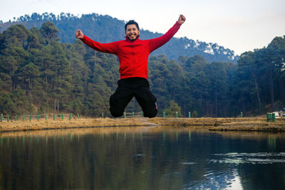 Rear view of man jumping in lake