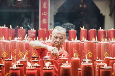 Man igniting candle in temple