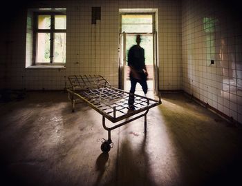 Rear view of man walking in corridor of building