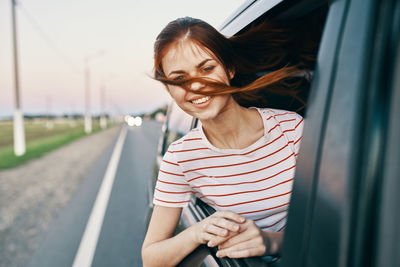 Portrait of smiling young woman in car