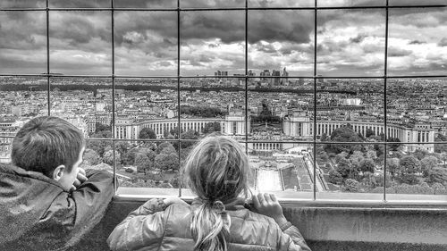 Rear view of girl looking through window