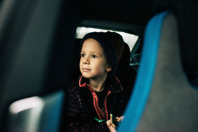 Portrait of boy looking through car