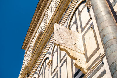 Ancient stone sundial on the facade of a medieval florentine church